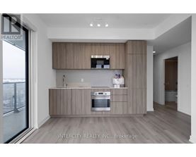 A modern kitchen with wooden cabinets and a stainless steel oven.