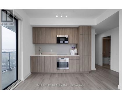 A modern kitchen with wooden cabinets and a stainless steel oven.