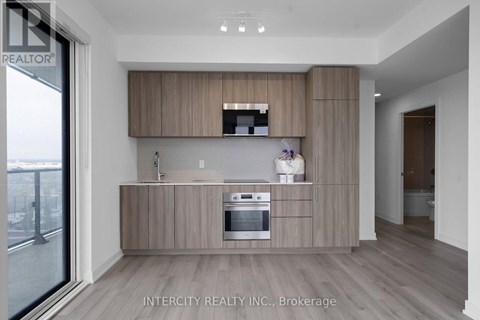 A modern kitchen with wooden cabinets and a stainless steel oven.