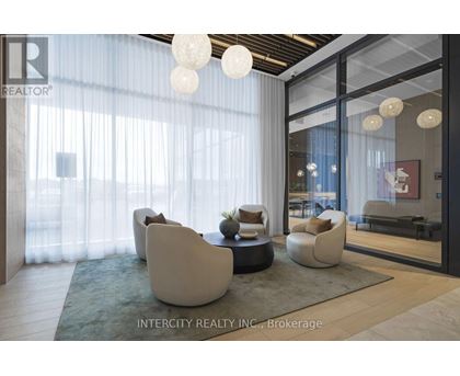 A modern living room with white furniture and a glass door leading to a balcony.