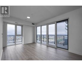 A spacious room with large windows overlooking a cityscape.
