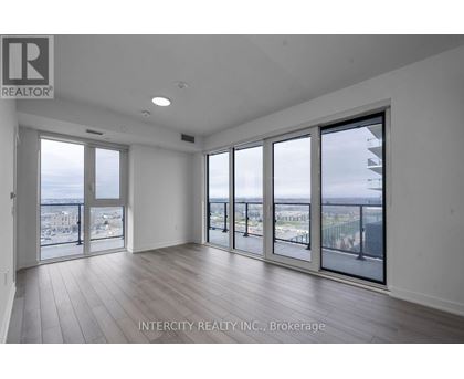 A spacious room with large windows overlooking a cityscape.