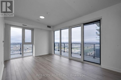A spacious room with large windows overlooking a cityscape.