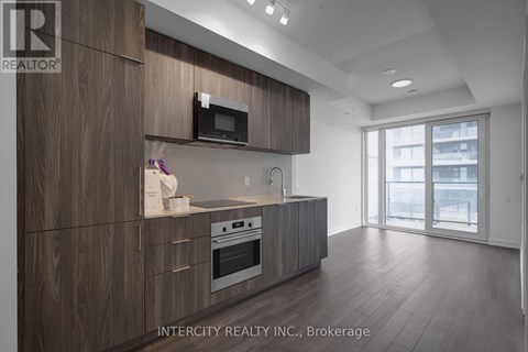 A modern kitchen with wooden cabinets and stainless steel appliances.