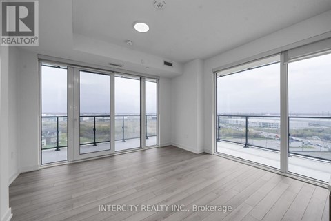 A spacious room with large windows overlooking a cityscape.