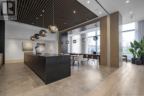 A modern office space with a black reception desk and wooden flooring.