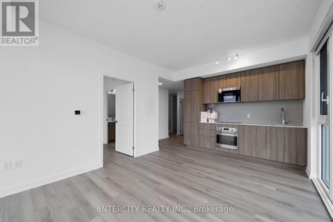 A kitchen with a stove top oven and microwave built into the cabinetry.