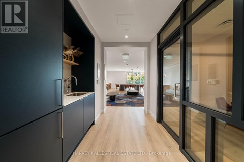 A modern kitchen with dark cabinets and a glass door.