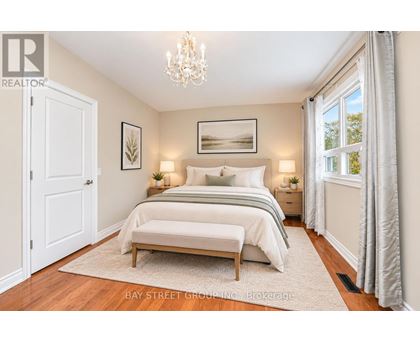 A bedroom with a large bed and a chandelier.