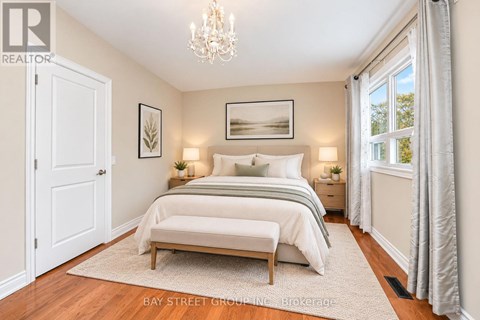 A bedroom with a large bed and a chandelier.
