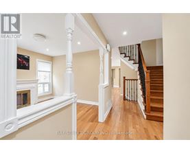 A spacious interior of a house with a staircase and a fireplace.