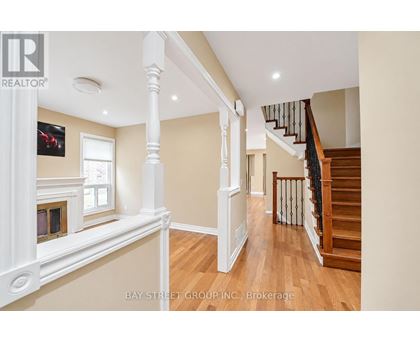 A spacious interior of a house with a staircase and a fireplace.