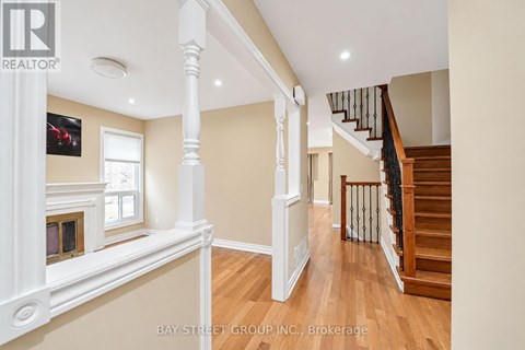 A spacious interior of a house with a staircase and a fireplace.