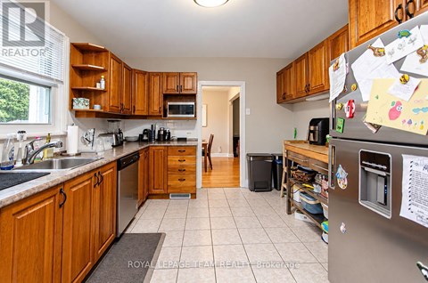 A kitchen with wooden cabinets and a refrigerator covered in notes.