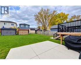 A backyard with a patio and a black grill.