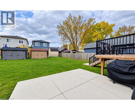 A backyard with a patio and a black grill.