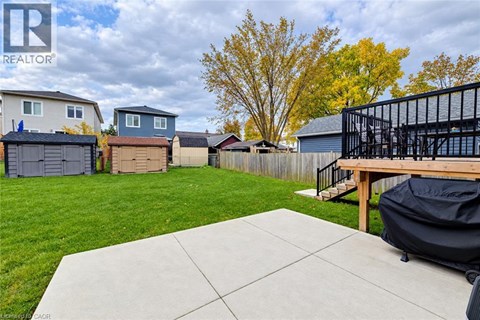 A backyard with a patio and a black grill.