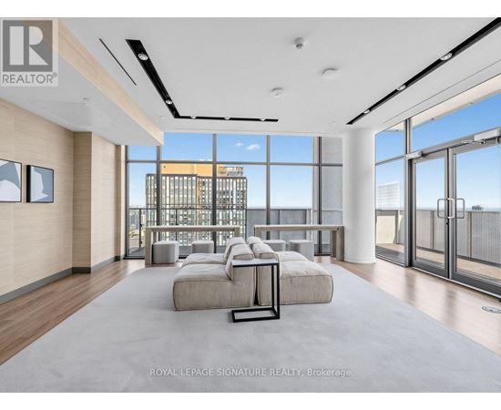 A spacious living room with a view of the cityscape outside the large windows.