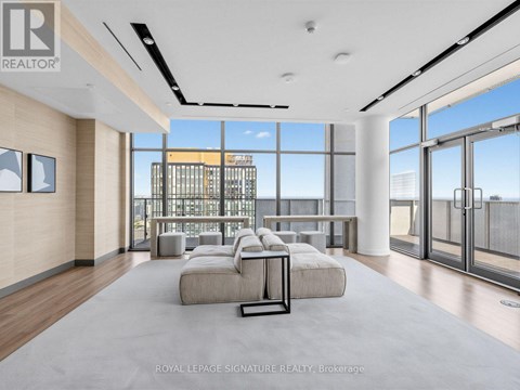 A spacious living room with a view of the cityscape outside the large windows.