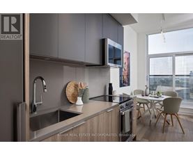 A modern kitchen with a sink, stove, and microwave.