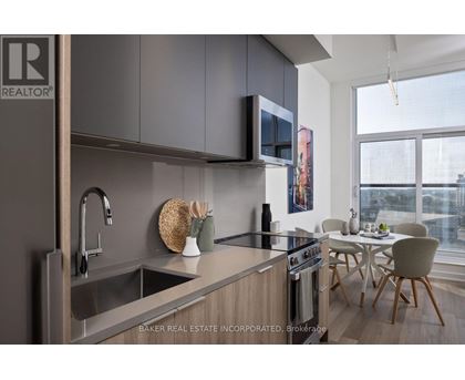 A modern kitchen with a sink, stove, and microwave.