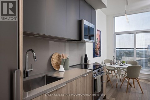 A modern kitchen with a sink, stove, and microwave.