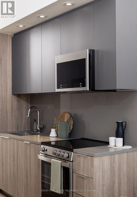 A modern kitchen with a stove top oven and a microwave above it.