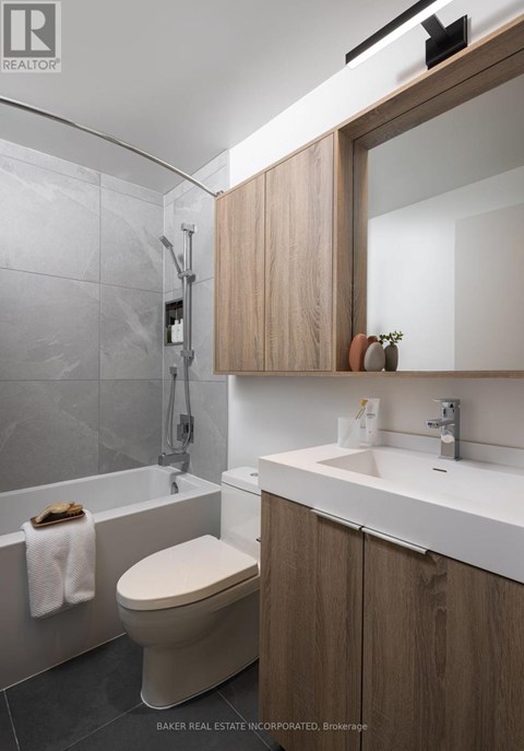 A modern bathroom with a toilet, sink, and a mirror.