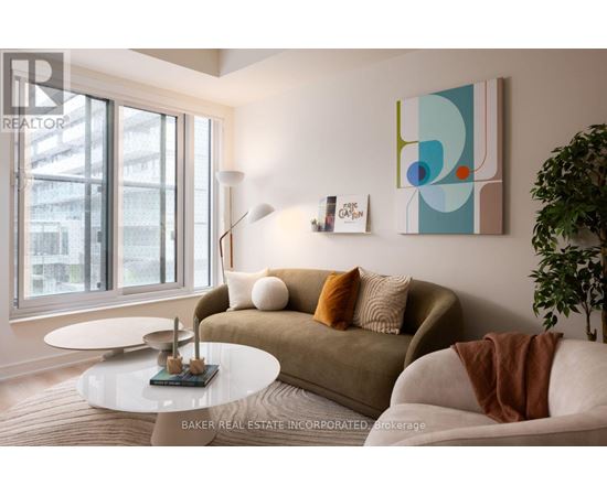 A living room with a couch, a table, and a painting on the wall.