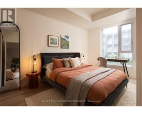 A bedroom with a large bed and a view of a cityscape through the window.