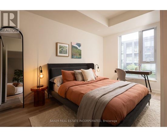 A bedroom with a large bed and a view of a cityscape through the window.
