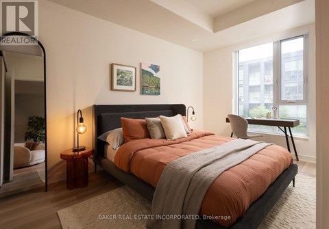 A bedroom with a large bed and a view of a cityscape through the window.
