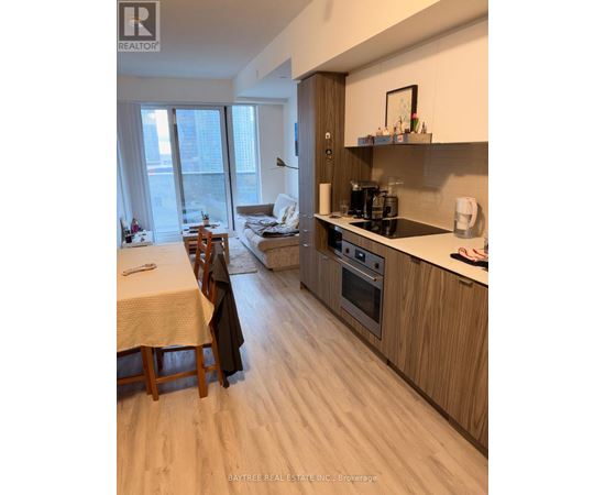 A well-lit kitchen with wooden floors and furniture.