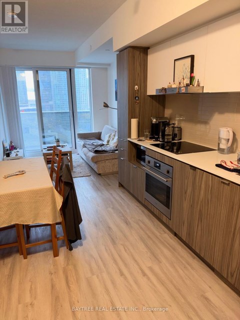 A well-lit kitchen with wooden floors and furniture.