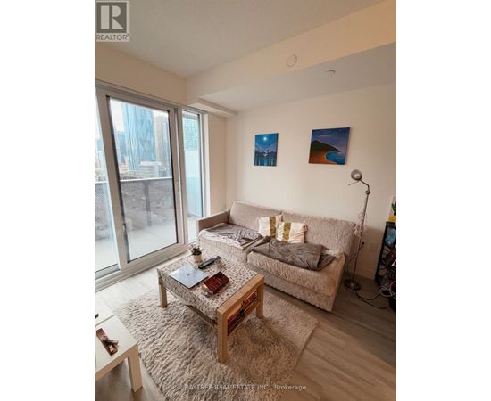 A living room with a couch, a coffee table, and a window.