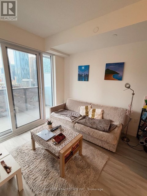 A living room with a couch, a coffee table, and a window.