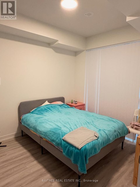 A bedroom with a bed, a nightstand, and a chair.