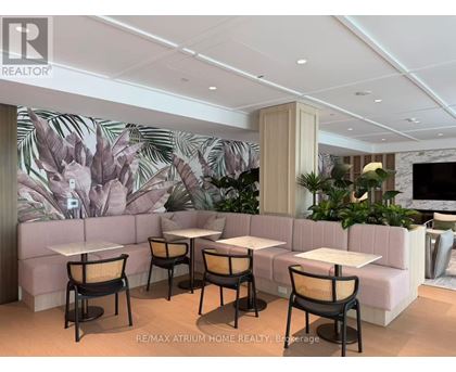 A modern dining area with a large mural of leaves on the wall.