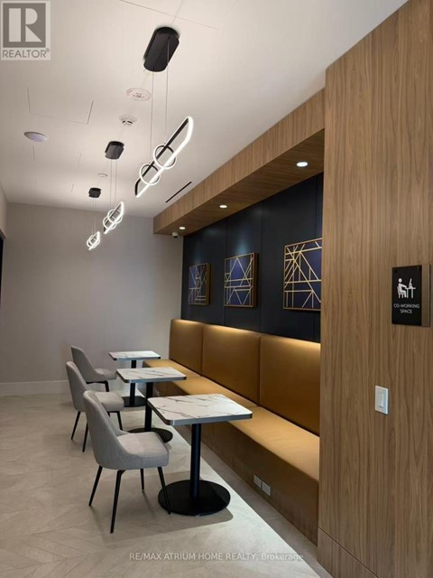 A modern dining area with wooden booths and white tables.
