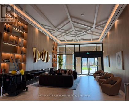 A spacious lobby with a reception desk and a large sculpture on the wall.