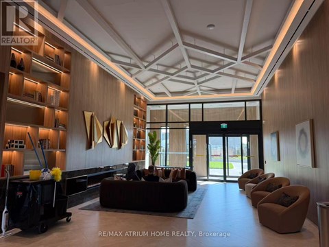 A spacious lobby with a reception desk and a large sculpture on the wall.