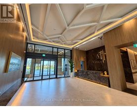 The image shows the interior of a modern building with a reception area.