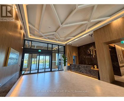 The image shows the interior of a modern building with a reception area.