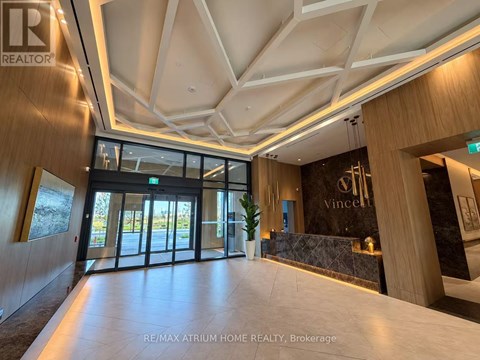 The image shows the interior of a modern building with a reception area.