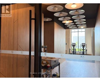 A modern kitchen with wooden cabinets and a black pole.