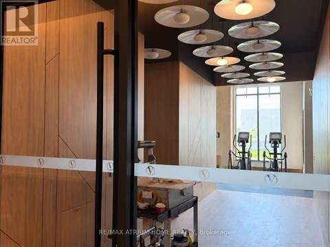 A modern kitchen with wooden cabinets and a black pole.