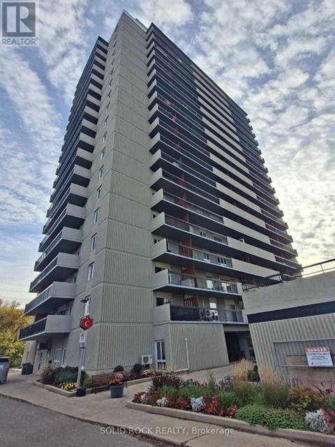 A tall building with a sign that says "SOLID ROCK REALTY Brokerage" in front of it.