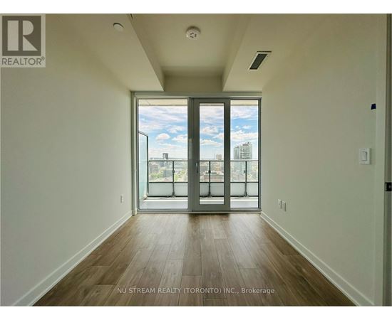 A room with a sliding glass door leading to a balcony.