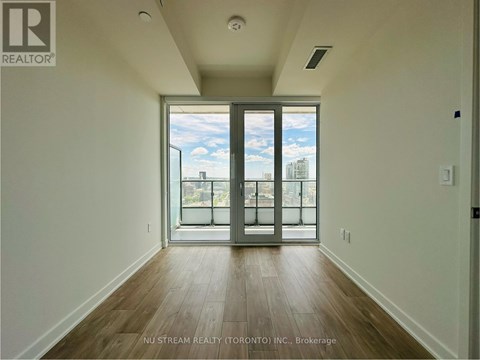 A room with a sliding glass door leading to a balcony.