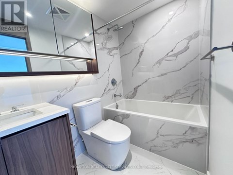 A white toilet in a marble bathroom.